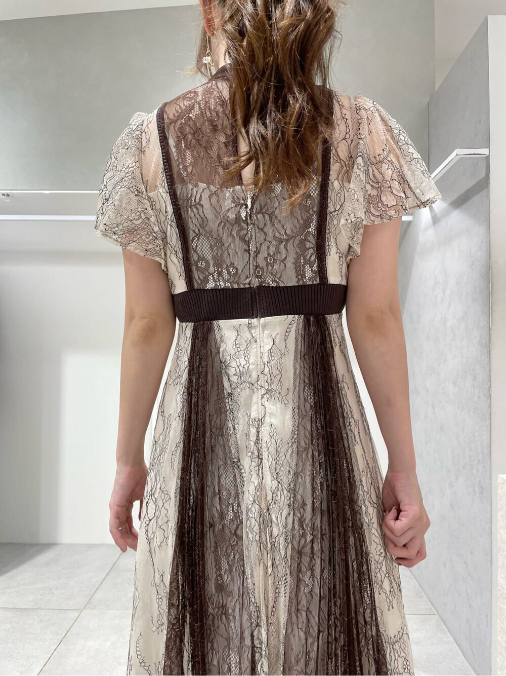 ブラック系のパンプス、ホワイト系のワンピース、ベージュ系のカーディガン/ボレロを着用したレディースの秋コーディネートの8枚目の写真