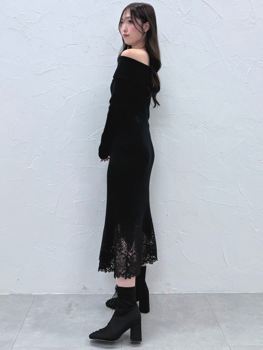 ブラック系のワンピース、ブラック系のブーツを着用したレディースの秋コーディネートの3枚目の写真