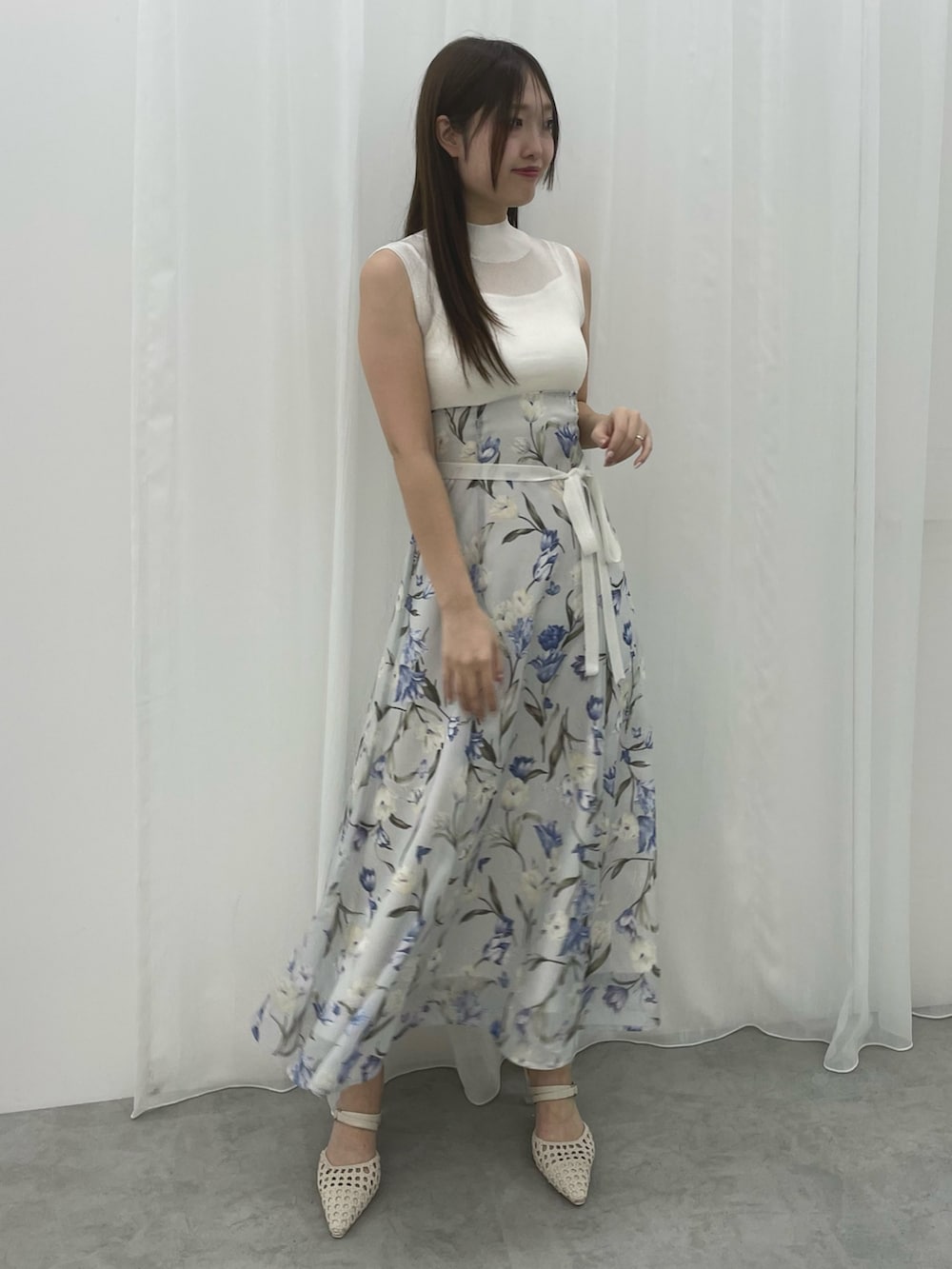 ブルー系のワンピース、ホワイト系のテーラードジャケット、ホワイト系のパンプスを着用したレディースの春コーディネートの7枚目の写真