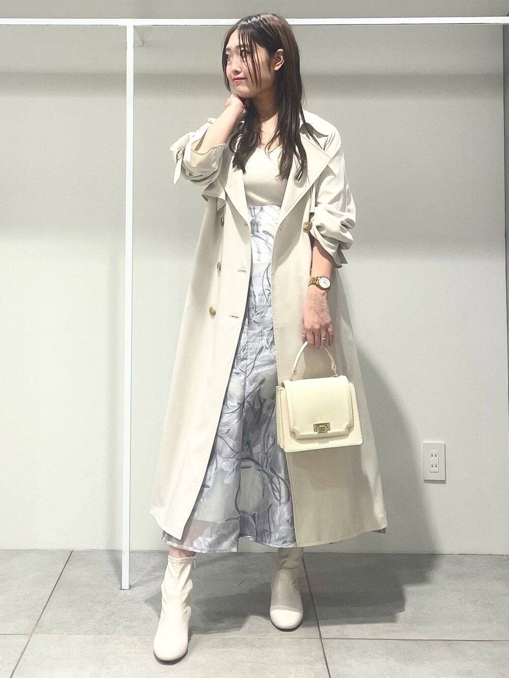ホワイト系のトレンチコート、ホワイト系のハンドバッグ、パープル系のワンピースを着用したレディースの春コーディネートの2枚目の写真