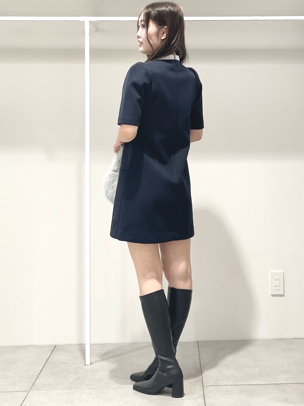 ブルー系のワンピース、ブラック系のブーツ、グレー系のハンドバッグを着用したレディースの秋コーディネートの3枚目の写真