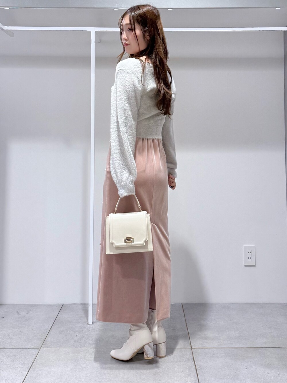 グレー系のカーディガン/ボレロ、ピンク系のスカート、ホワイト系のハンドバッグを着用したレディースの冬コーディネートの3枚目の写真