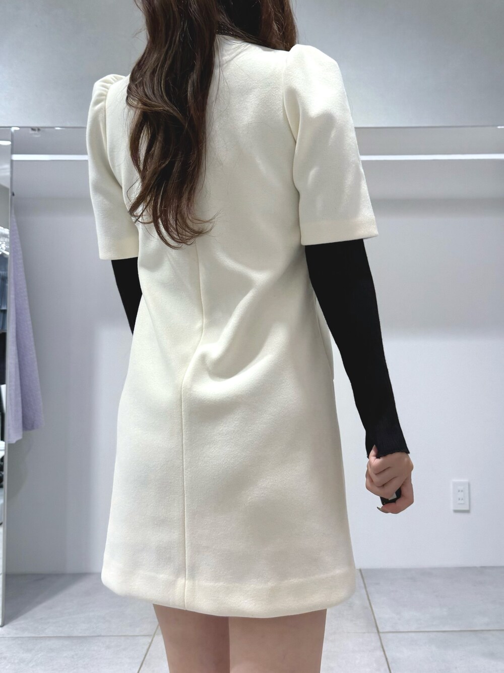 ホワイト系のワンピース、ブラック系のニット/セーター、ブラウン系のハンドバッグを着用したレディースの秋コーディネートの7枚目の写真