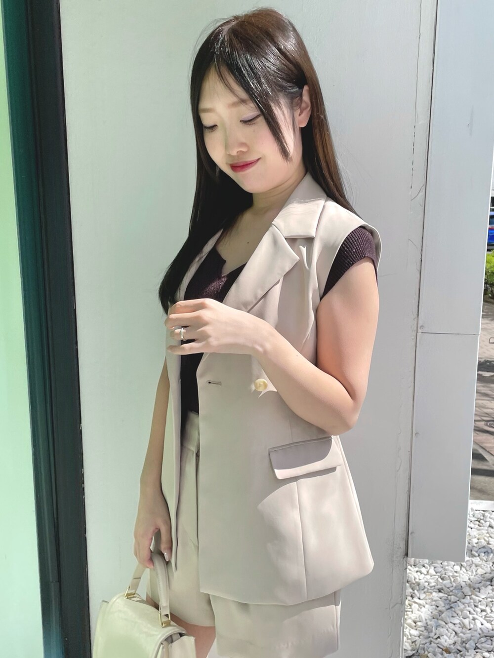 ベージュ系のその他パンツ、ホワイト系のハンドバッグ、ブラウン系のサンダルを着用したレディースの春コーディネートの4枚目の写真