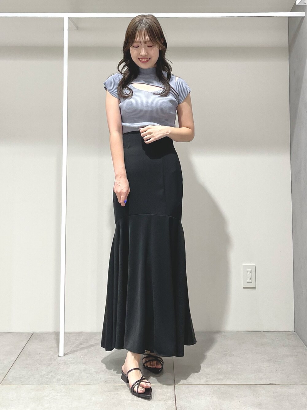 ブルー系のニット/セーター、ブラック系のスカート、ブラック系のサンダルを着用したレディースの夏コーディネートの2枚目の写真