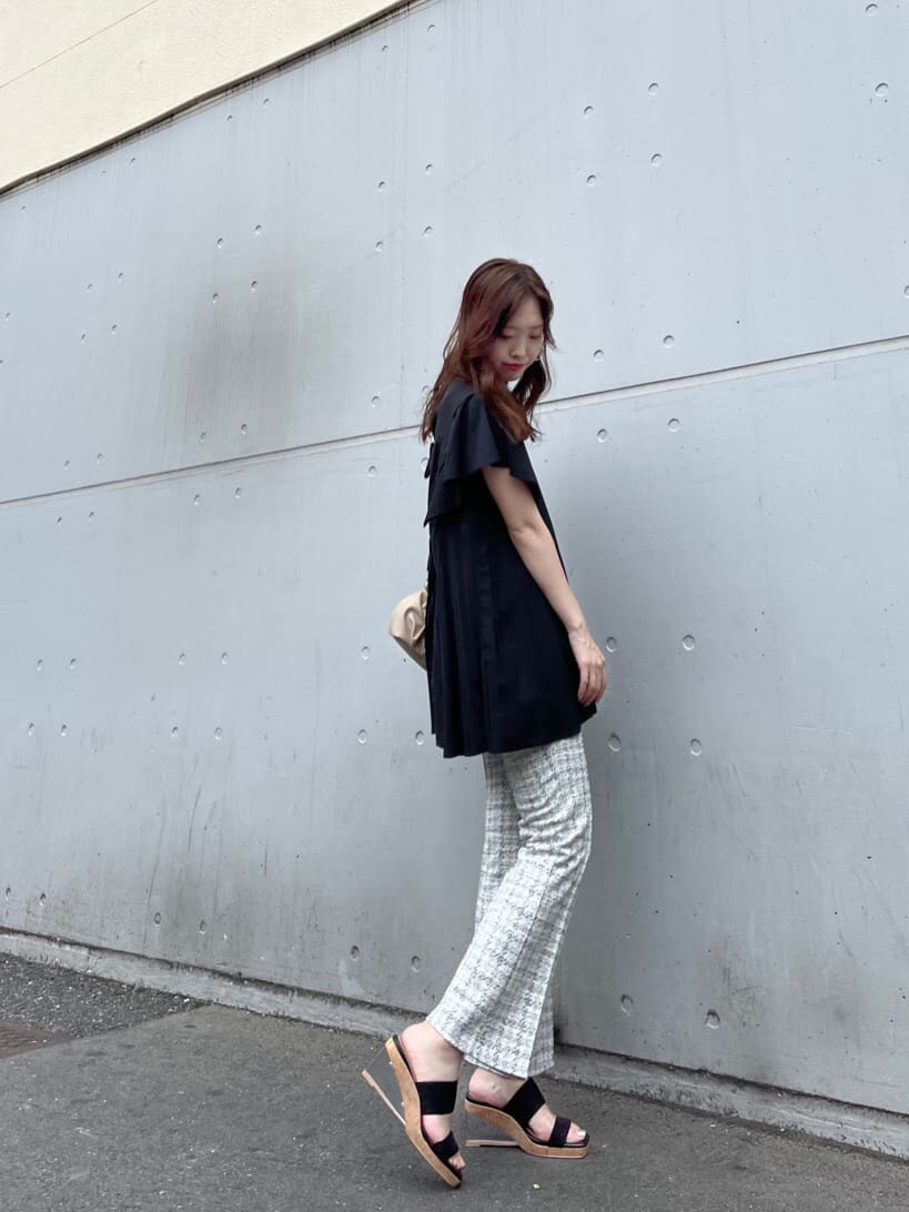 ブラック系のサンダル、ブラック系のシャツ/ブラウス、ホワイト系のクラッチバッグを着用したレディースの夏コーディネートの2枚目の写真