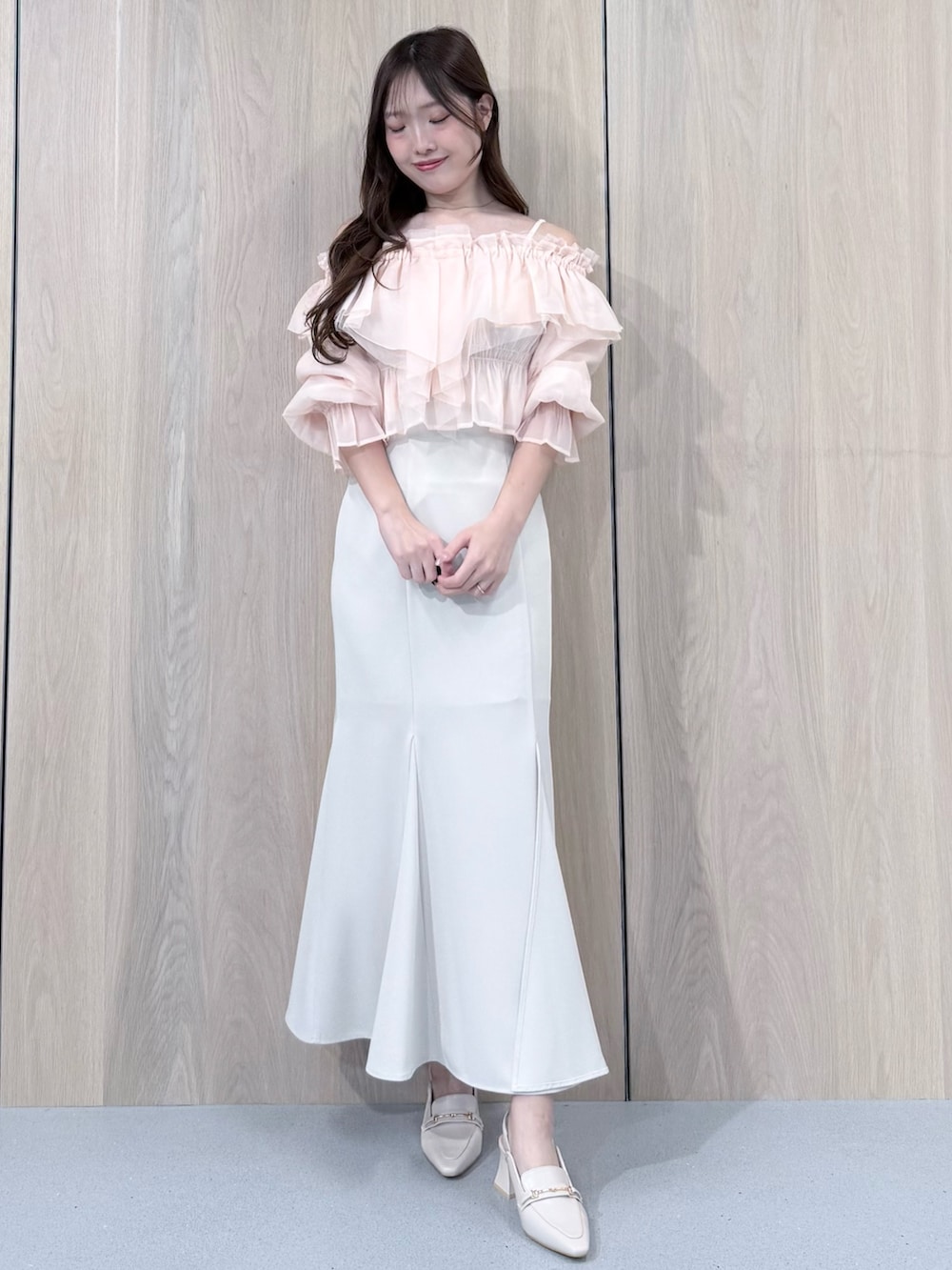ピンク系のシャツ/ブラウス、ホワイト系のスカート、ホワイト系のパンプスを着用したレディースの春コーディネートの2枚目の写真