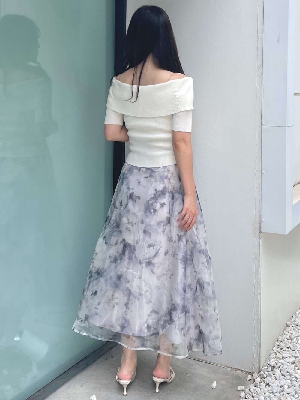 ホワイト系のニット/セーター、グレー系のスカート、ベージュ系のパンプスを着用したレディースの夏コーディネートの4枚目の写真