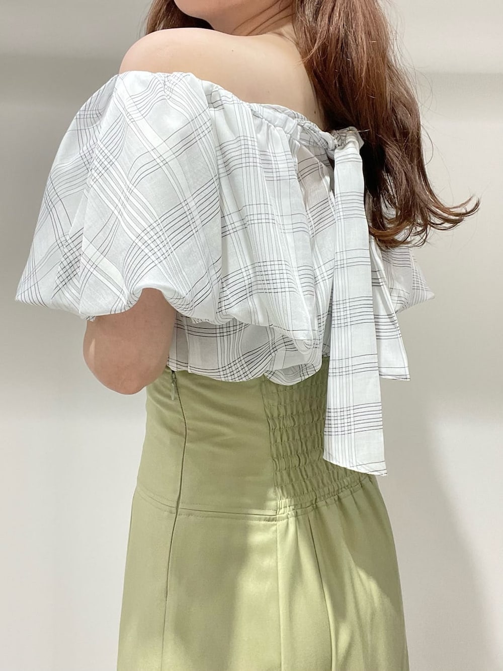 ホワイト系のキャミソール、グリーン系のスカート、ベージュ系のサンダルを着用したレディースの夏コーディネートの6枚目の写真