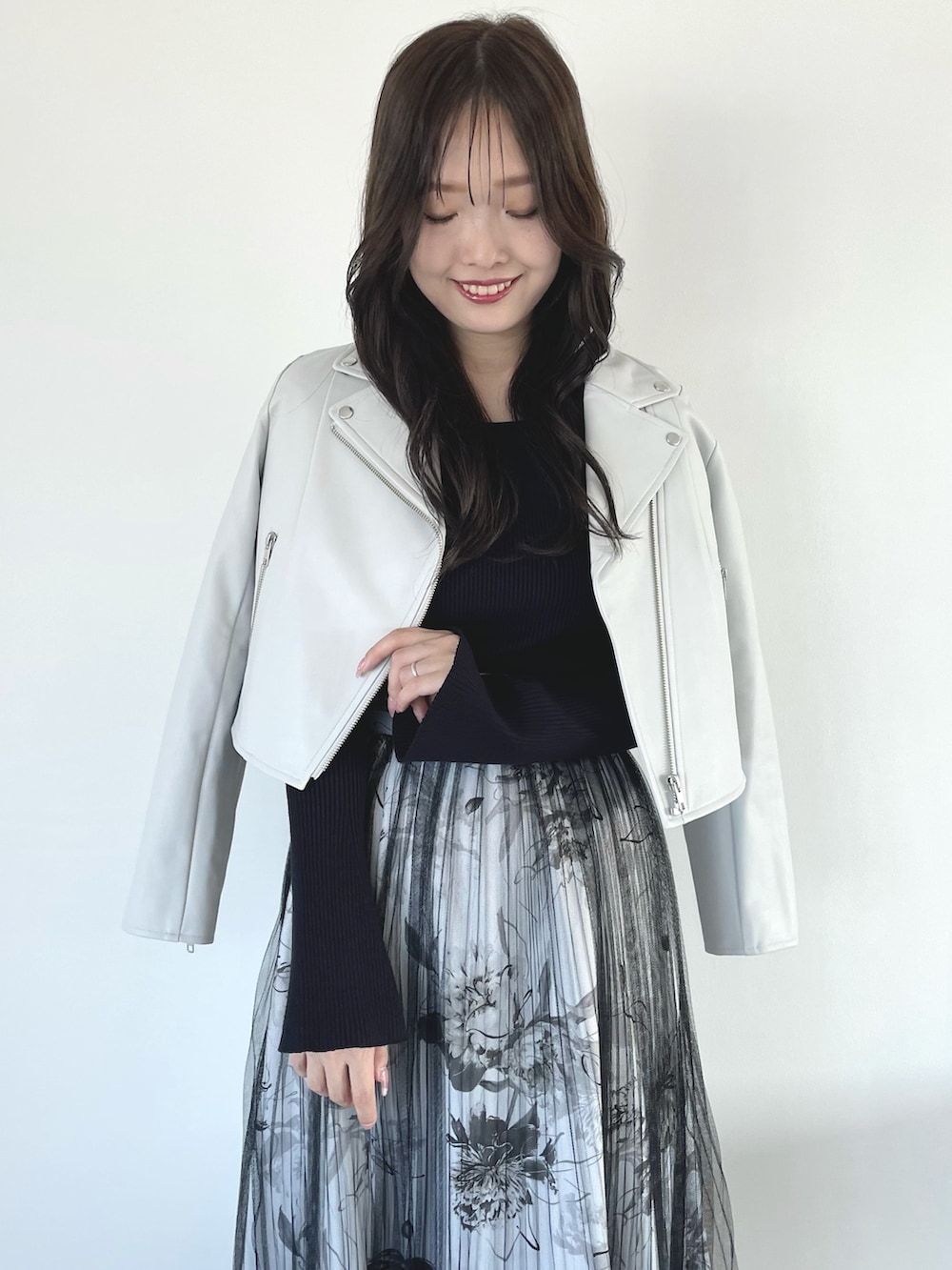 ブラック系のブーツ、ブラック系のスカート、ブラック系のハンドバッグを着用したレディースの春コーディネートの9枚目の写真