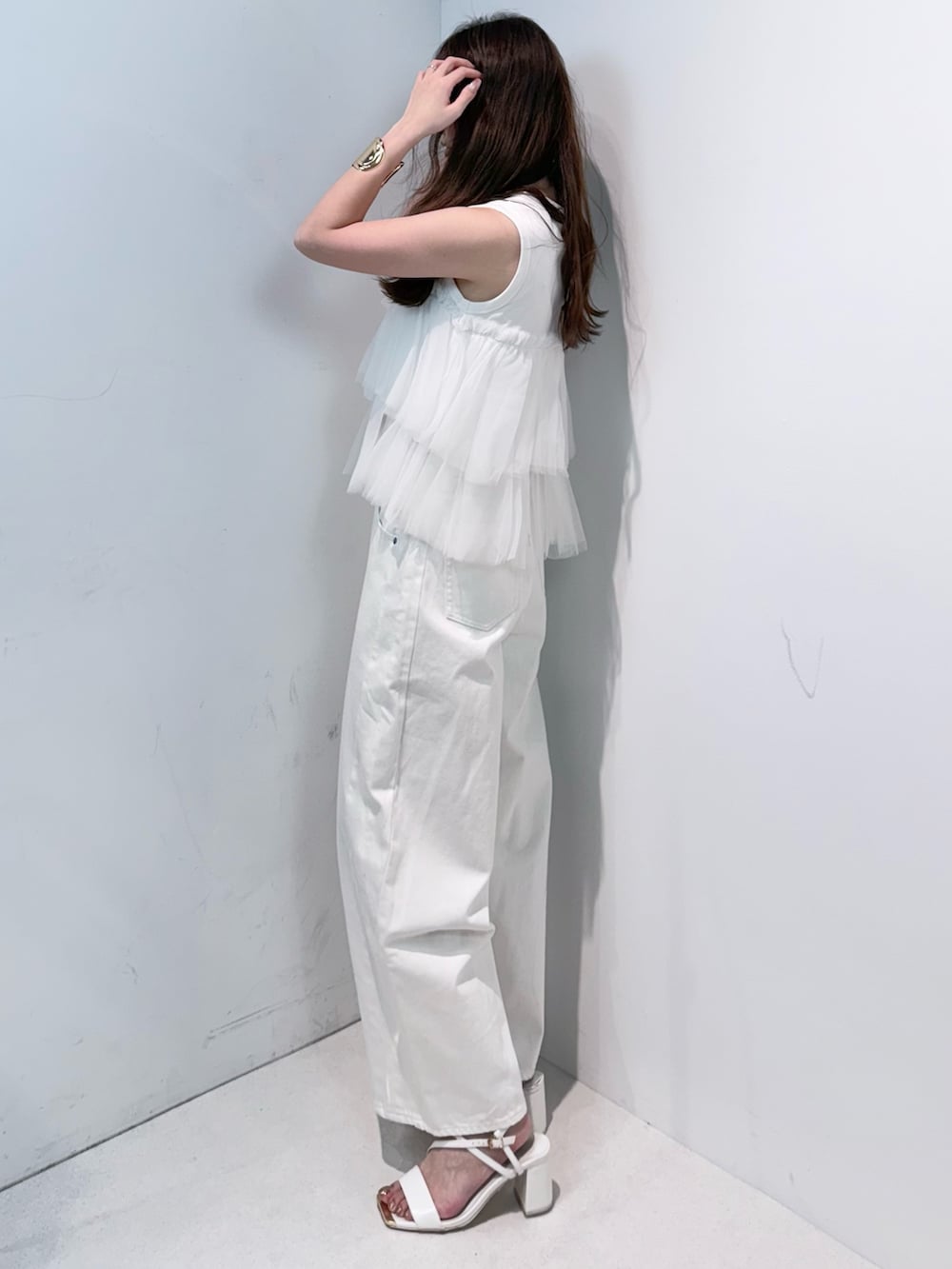 ホワイト系のデニムパンツ、ホワイト系のサンダル、ホワイト系のTシャツ/カットソーを着用したレディースの春コーディネートの2枚目の写真