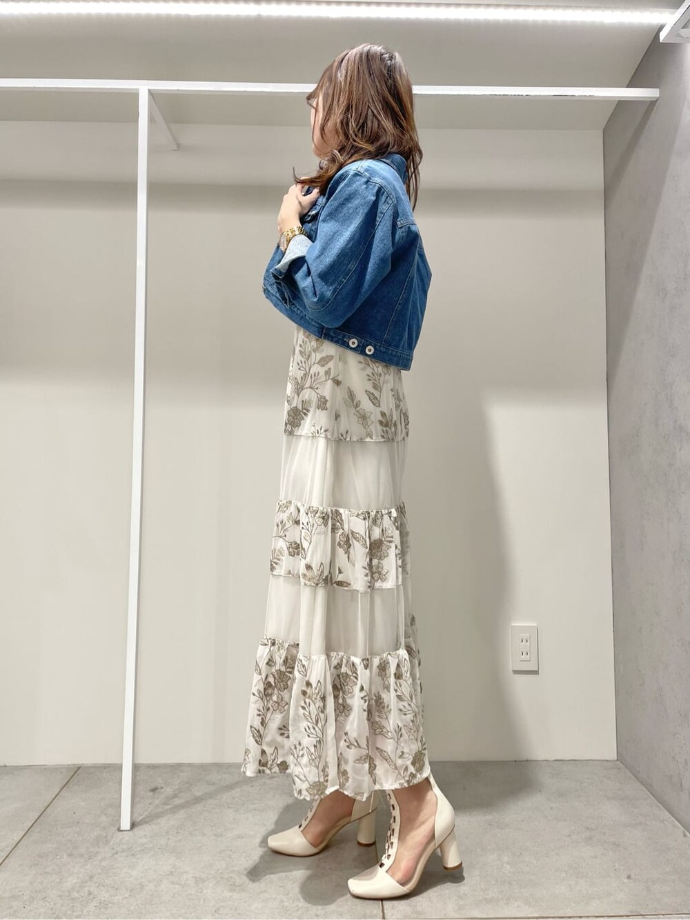 ブルー系のテーラードジャケット、ベージュ系のワンピースを着用したレディースの春コーディネートの2枚目の写真