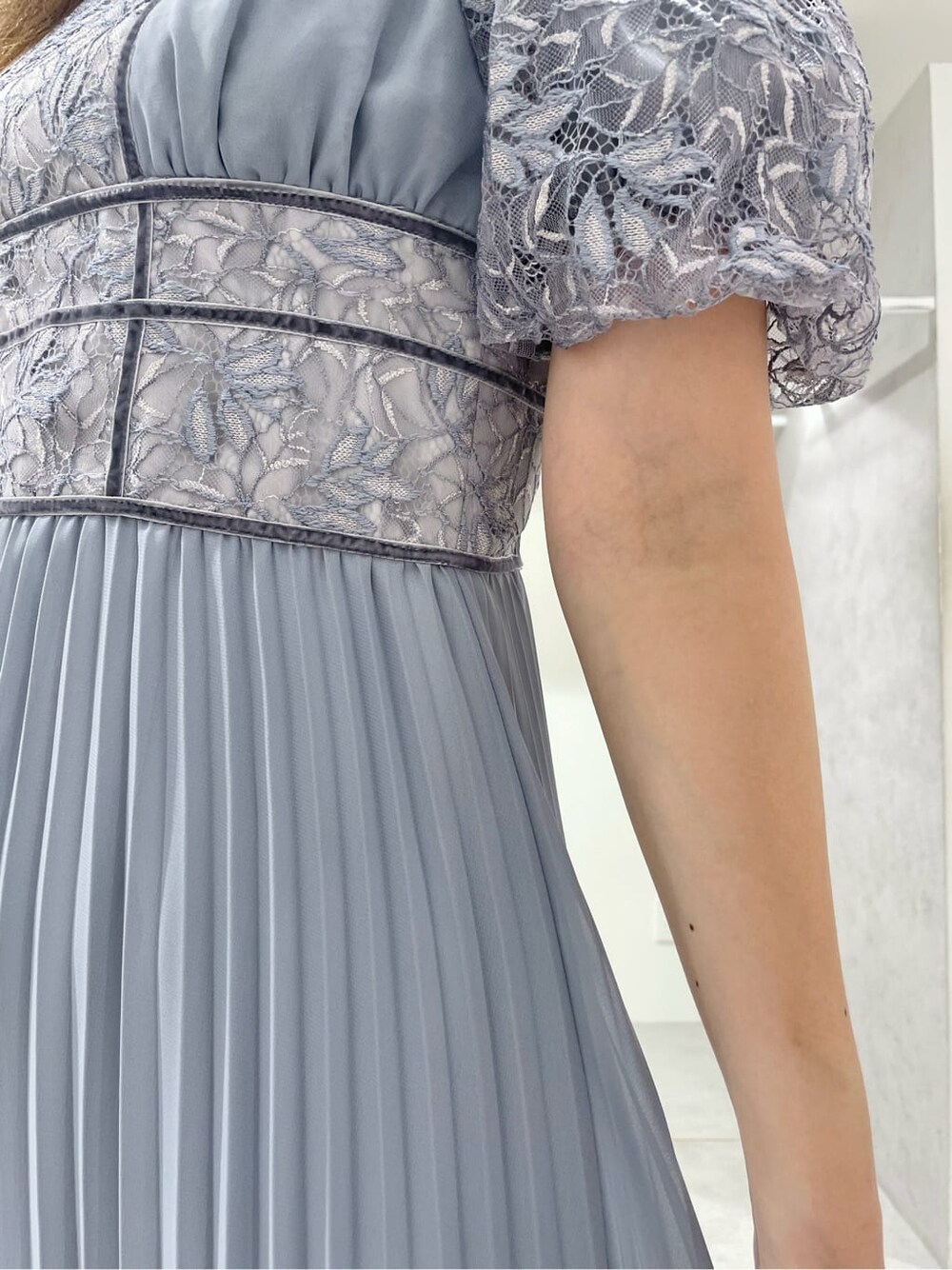 ブラック系のパンプス、ブルー系のワンピース、シルバー系のイヤリングを着用したレディースの秋コーディネートの8枚目の写真