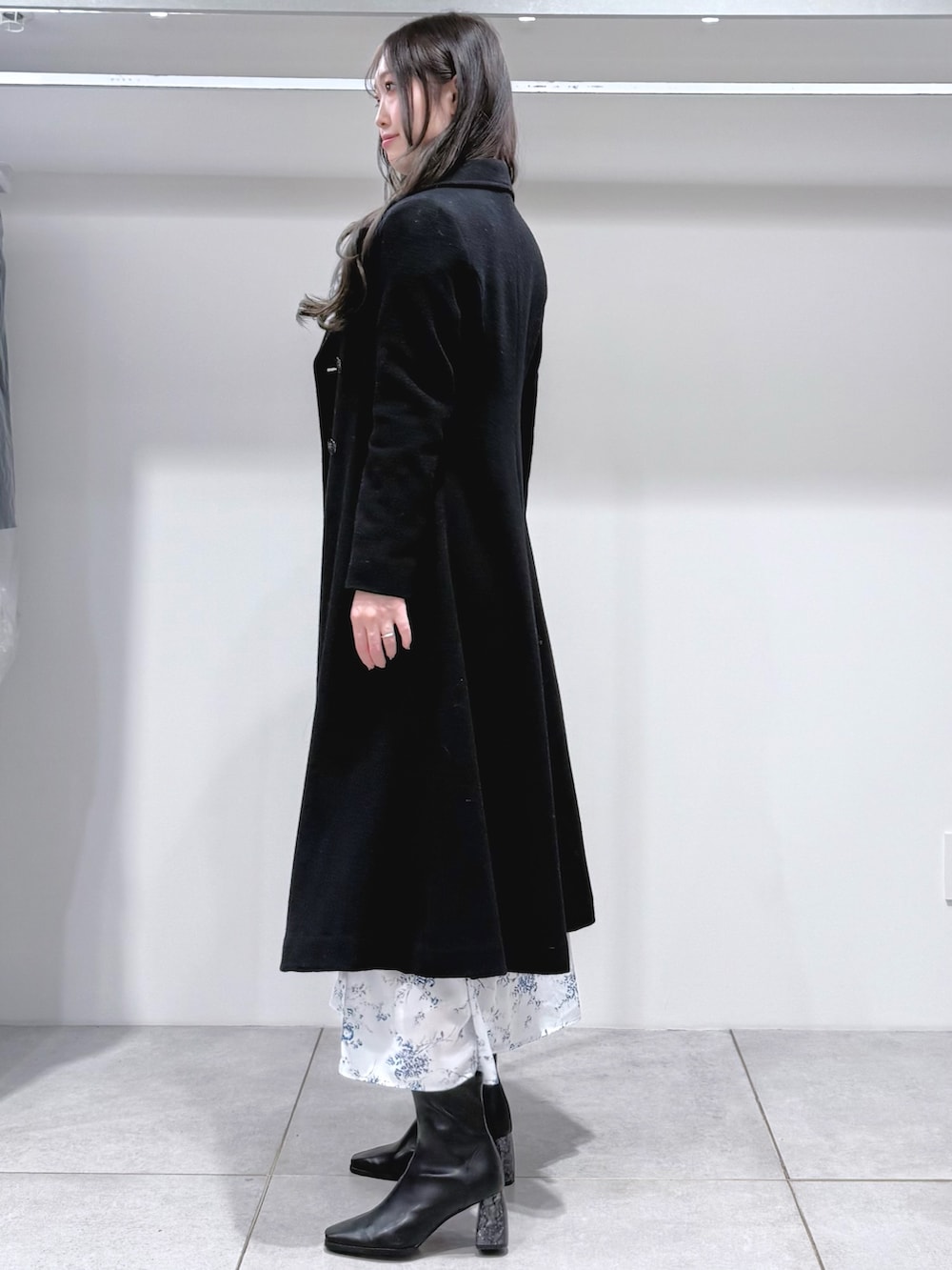 ブルー系のワンピース、ブラック系のブーツ、ブラック系のその他アウターを着用したレディースの冬コーディネートの3枚目の写真