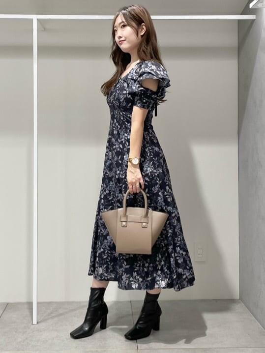 ブルー系のワンピース、ブラック系のブーツ、ブラウン系のハンドバッグを着用したレディースの秋コーディネートの3枚目の写真