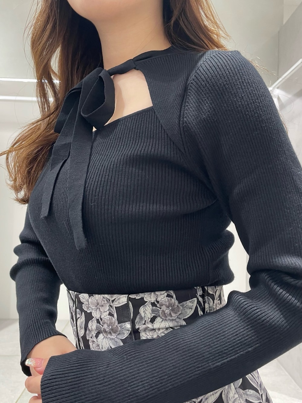 ベージュ系のチェスターコート、ブラック系のブーツ、ブラック系のスカートを着用したレディースの冬コーディネートの8枚目の写真