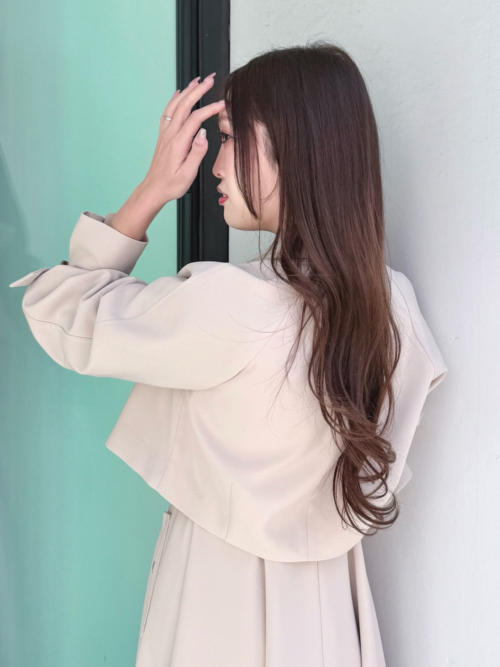 ベージュ系のワンピース、ベージュ系のブーツ、ベージュ系のトレンチコートを着用したレディースの冬コーディネートの5枚目の写真