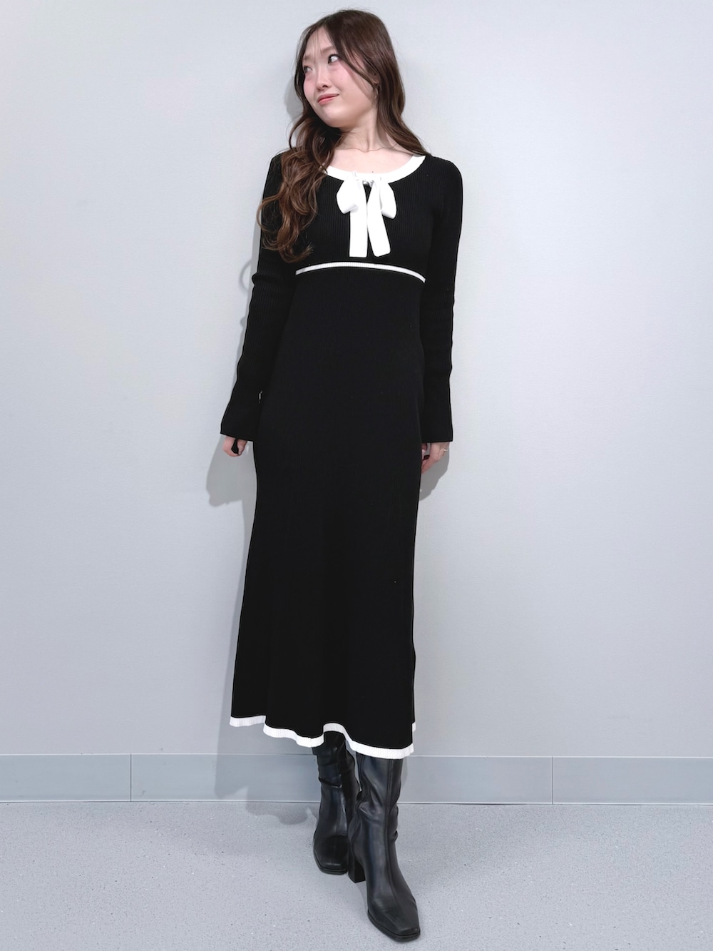 ホワイト系のテーラードジャケット、ブラック系のワンピース、ブラック系のブーツを着用したレディースの冬コーディネートの7枚目の写真