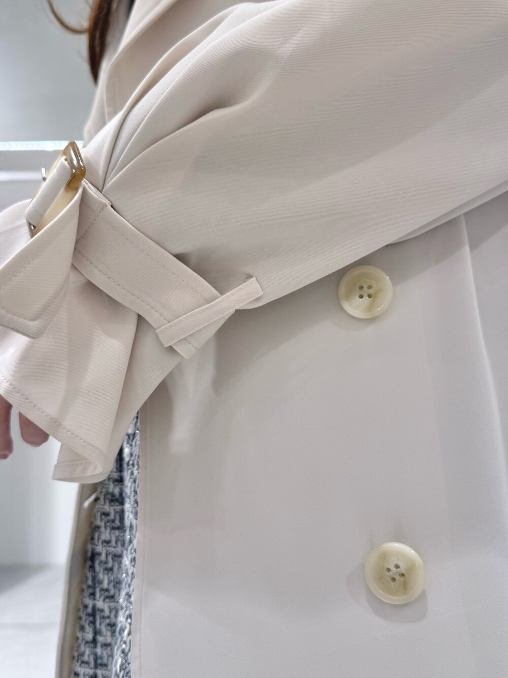 ホワイト系のトレンチコート、ブラック系のワンピース、ブラック系のブーツを着用したレディースの冬コーディネートの7枚目の写真