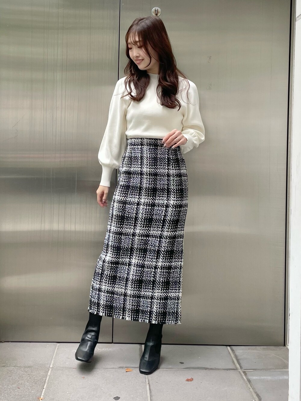 グリーン系のカーディガン/ボレロ、ブラック系のスカート、ブラック系のブーツを着用したレディースの秋コーディネートの5枚目の写真