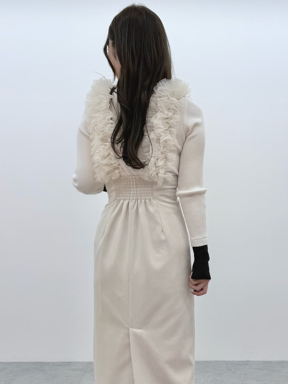 ホワイト系のスカート、ホワイト系のニット/セーター、ブラック系のブーツを着用したレディースの冬コーディネートの7枚目の写真