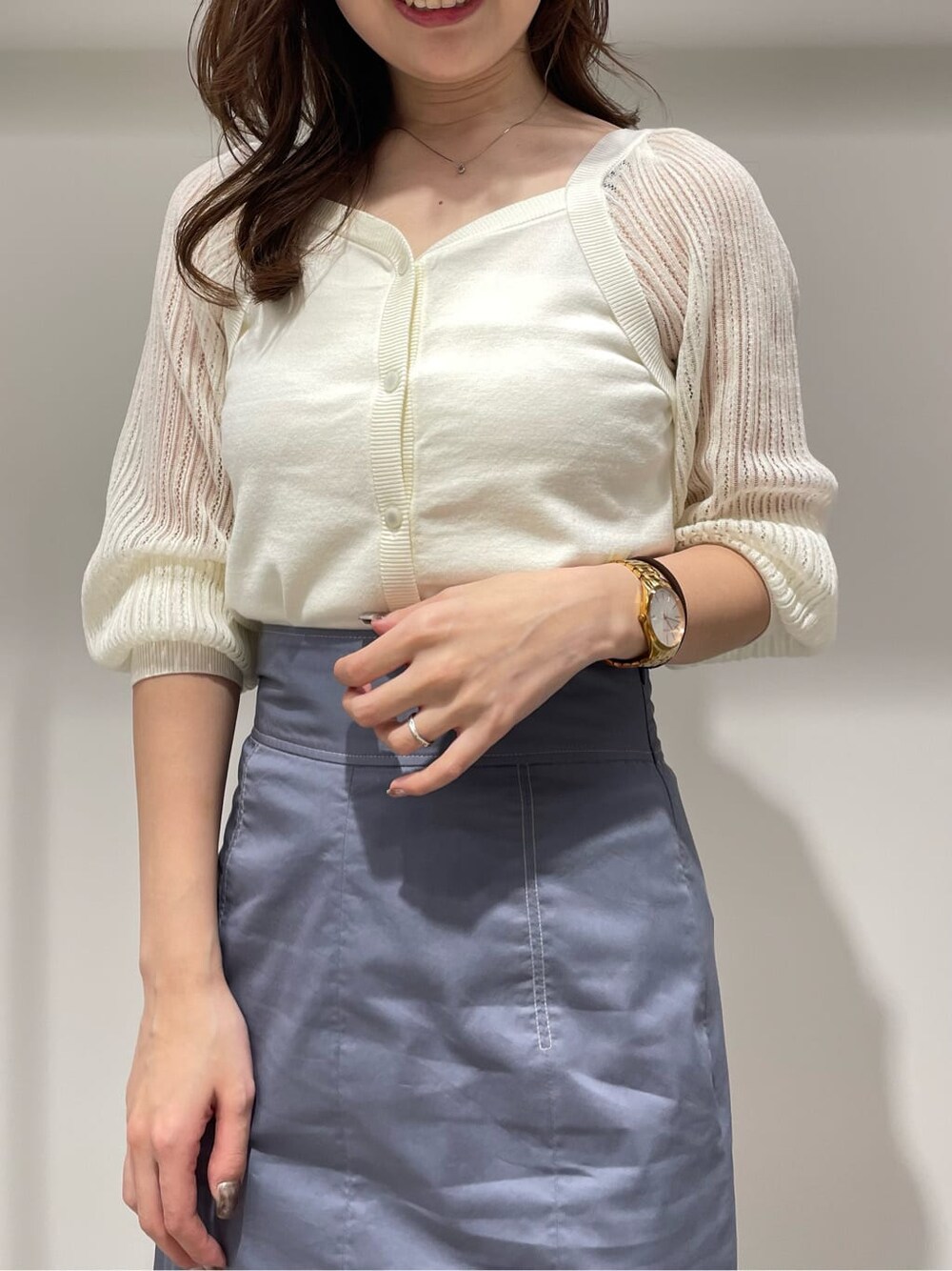 ブルー系のスカート、ホワイト系のニット/セーターを着用したレディースの春コーディネートの4枚目の写真