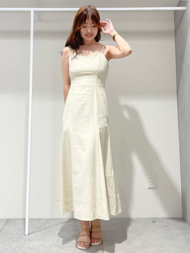 ベージュ系のサンダル、ベージュ系のトートバッグ、ホワイト系のワンピースを着用したレディースの春コーディネートの6枚目の写真