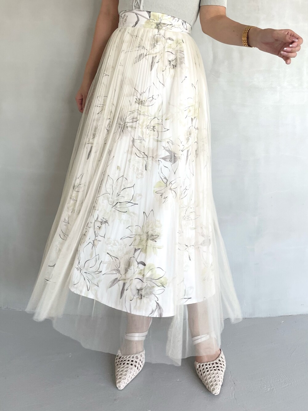 グリーン系のニット/セーター、イエロー系のスカート、ホワイト系のパンプスを着用したレディースの春コーディネートの6枚目の写真