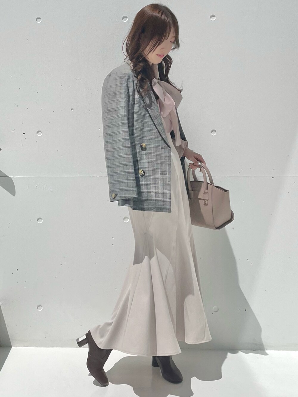 グレー系のテーラードジャケット、ベージュ系のシャツ/ブラウス、ベージュ系のスカートを着用したレディースの秋コーディネートの3枚目の写真
