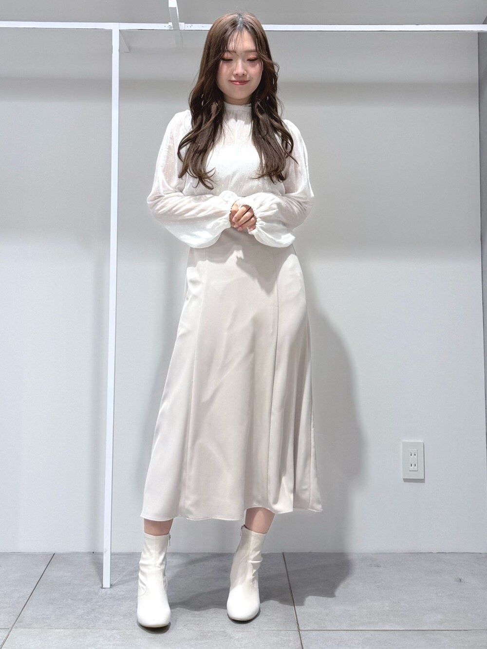 ホワイト系のワンピース、ホワイト系のブーツを着用したレディースの冬コーディネートの2枚目の写真