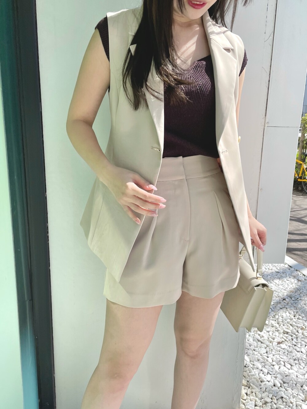 ベージュ系のその他パンツ、ホワイト系のハンドバッグ、ブラウン系のサンダルを着用したレディースの春コーディネートの6枚目の写真