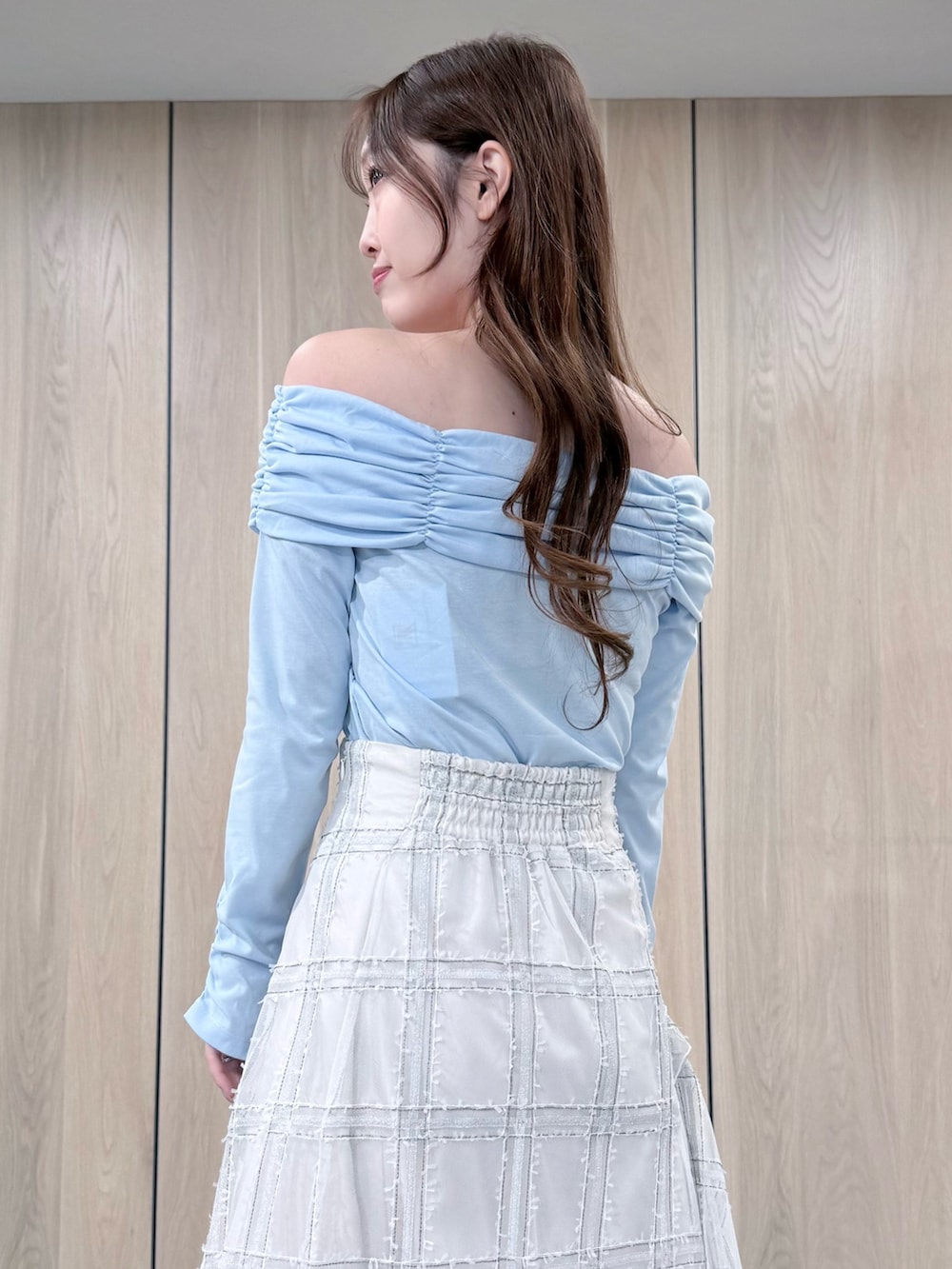 ブルー系のTシャツ/カットソー、ホワイト系のスカート、ブラウン系のブーツを着用したレディースの冬コーディネートの5枚目の写真