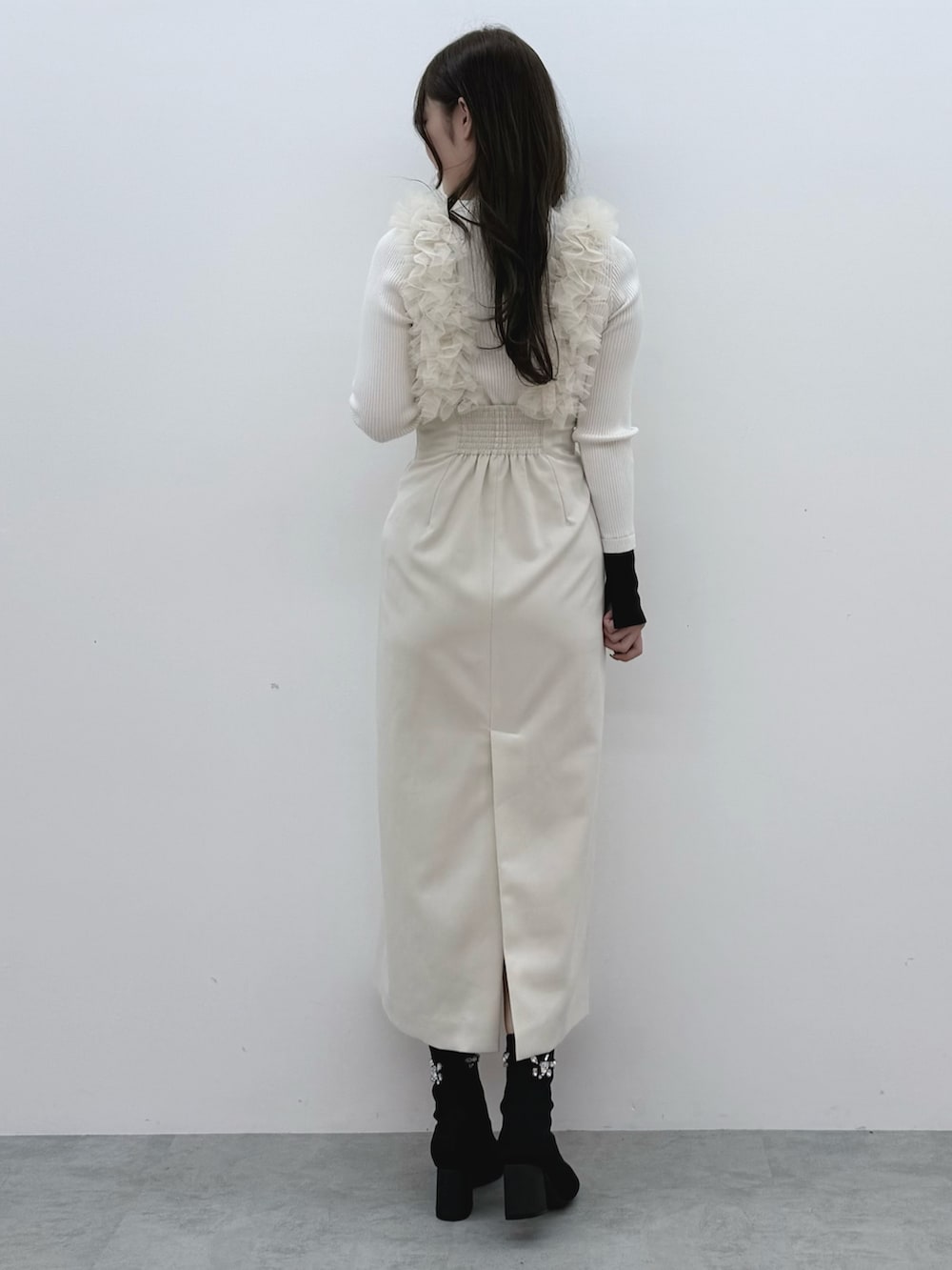 ホワイト系のスカート、ホワイト系のニット/セーター、ブラック系のブーツを着用したレディースの冬コーディネートの4枚目の写真