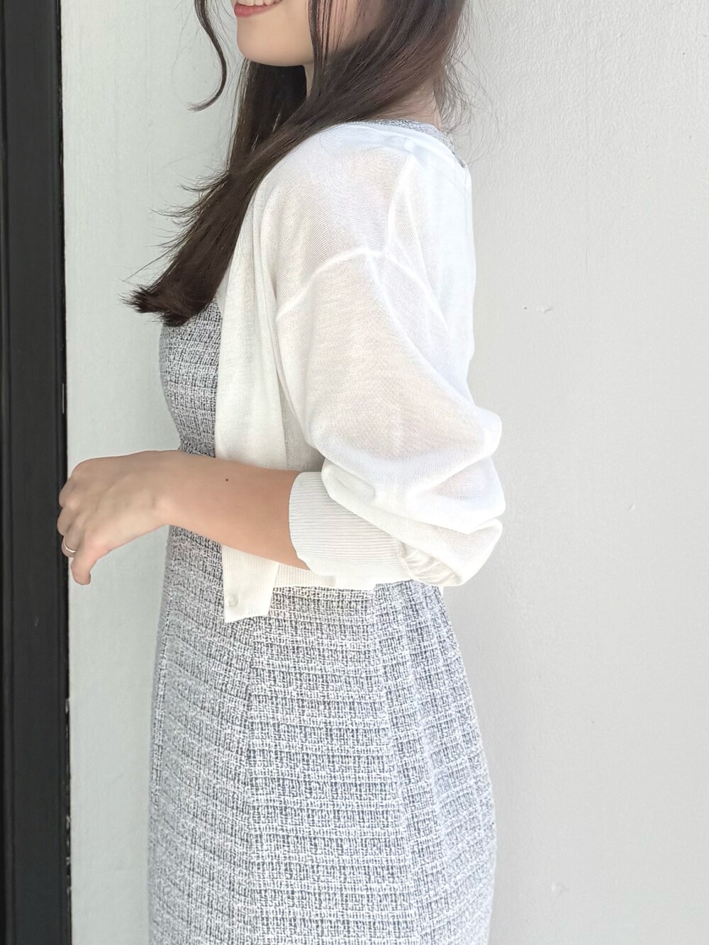 グレー系のワンピース、ホワイト系のカーディガン/ボレロ、その他のサンダルを着用したレディースの春コーディネートの5枚目の写真