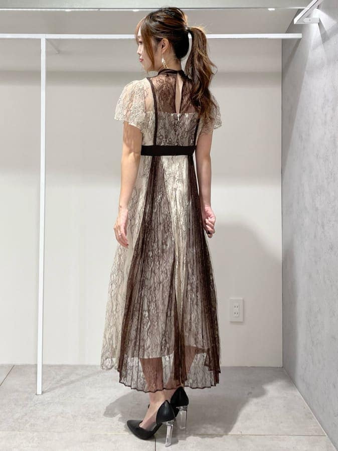 ブラック系のパンプス、ホワイト系のワンピース、ベージュ系のカーディガン/ボレロを着用したレディースの秋コーディネートの6枚目の写真