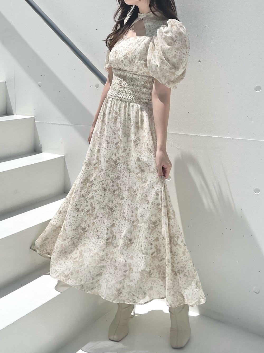 ベージュ系のワンピース、ホワイト系のブーツを着用したレディースの夏コーディネートの2枚目の写真