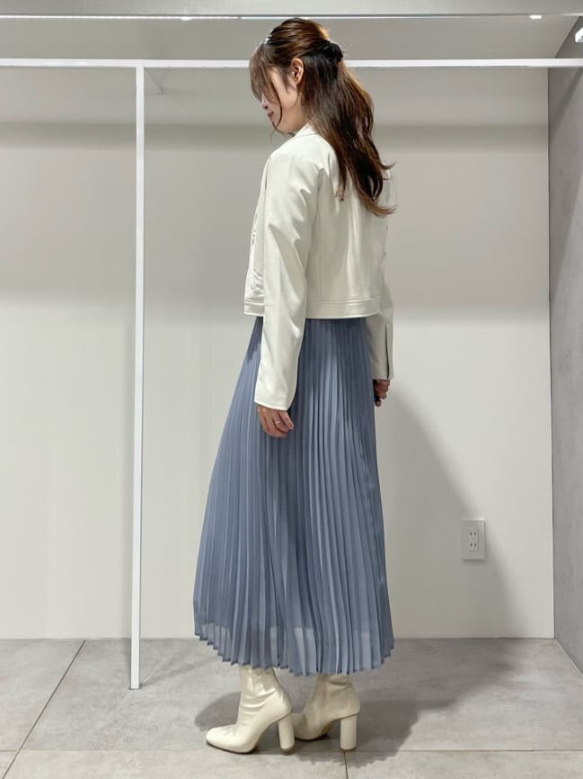 ホワイト系のブーツ、ホワイト系のライダースジャケット、ブルー系のワンピースを着用したレディースの秋コーディネートの3枚目の写真