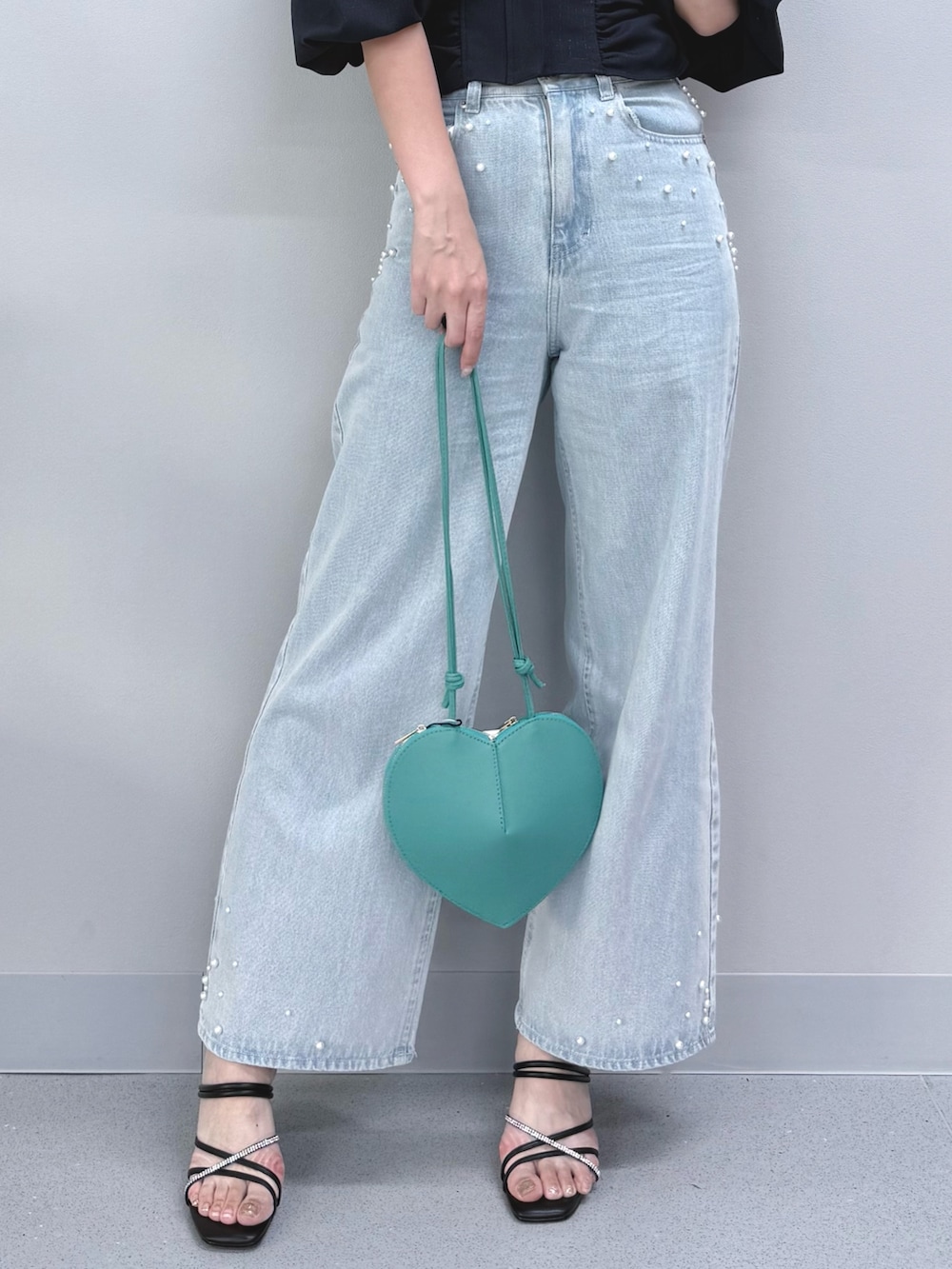 ブルー系のデニムパンツ、グリーン系のショルダーバッグ、ブラック系のサンダルを着用したレディースの夏コーディネートの8枚目の写真