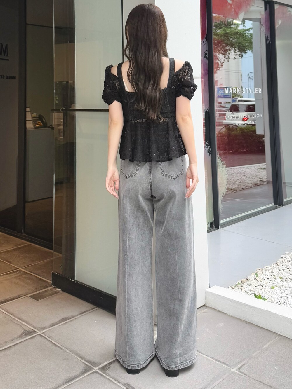 グレー系のデニムパンツ、ブラック系のサンダル、ブラック系のシャツ/ブラウスを着用したレディースの夏コーディネートの4枚目の写真