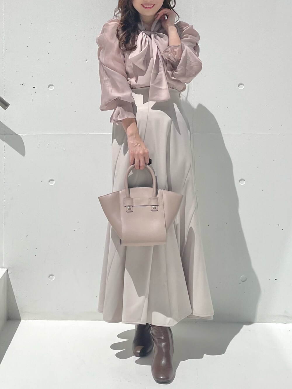 グレー系のテーラードジャケット、ベージュ系のシャツ/ブラウス、ベージュ系のスカートを着用したレディースの秋コーディネートの5枚目の写真