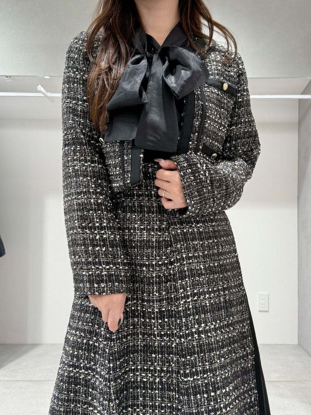 ブラック系のテーラードジャケット、ブラック系のスカート、ブラック系のシャツ/ブラウスを着用したレディースの秋コーディネートの4枚目の写真