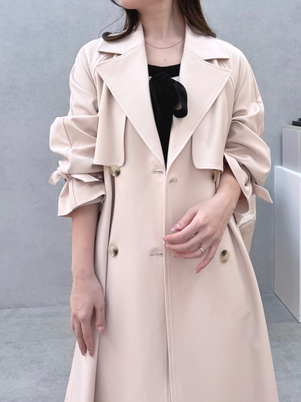 ホワイト系のワンピース、ピンク系のトレンチコート、ホワイト系のパンプスを着用したレディースの冬コーディネートの4枚目の写真