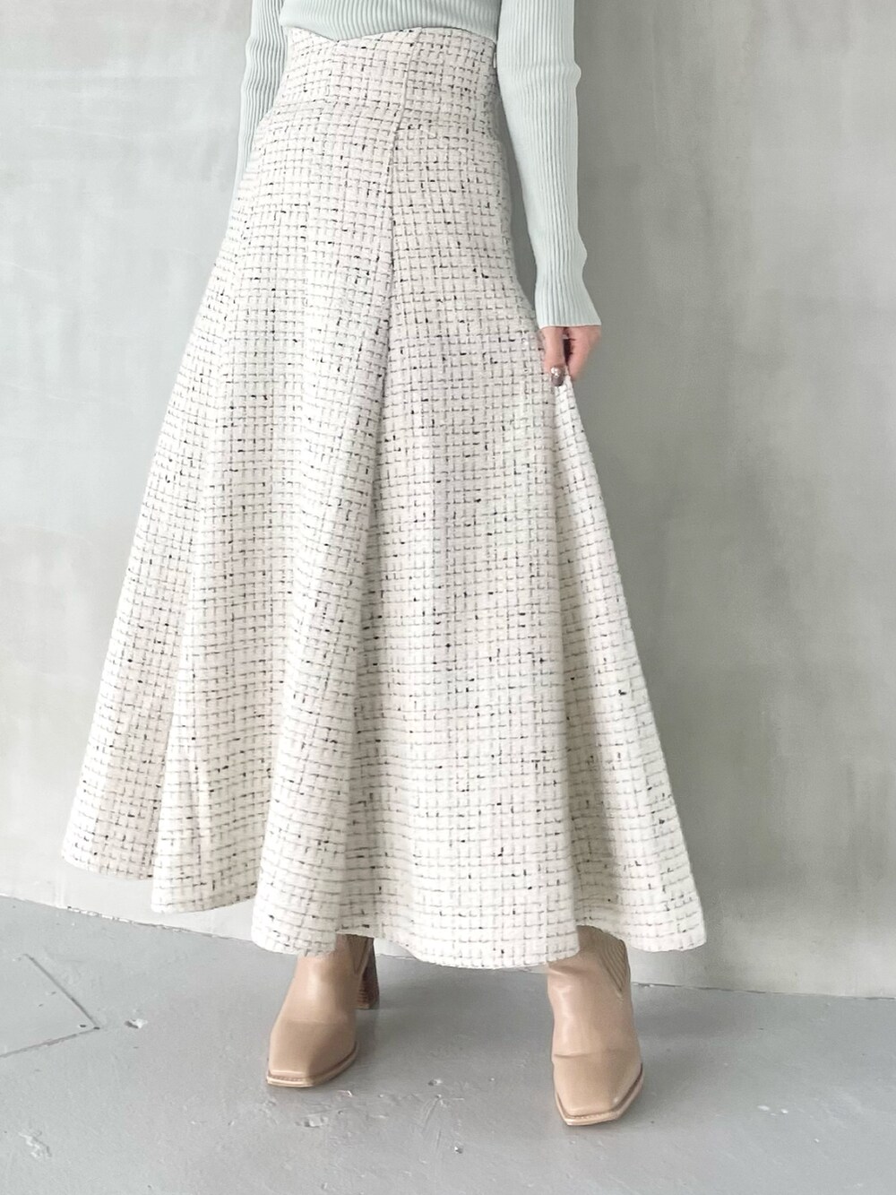 ホワイト系のスカート、ベージュ系のブーツ、グリーン系のニット/セーターを着用したレディースの秋コーディネートの7枚目の写真