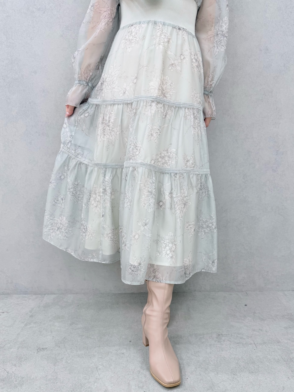 グリーン系のワンピース、ベージュ系のブーツを着用したレディースの冬コーディネートの7枚目の写真