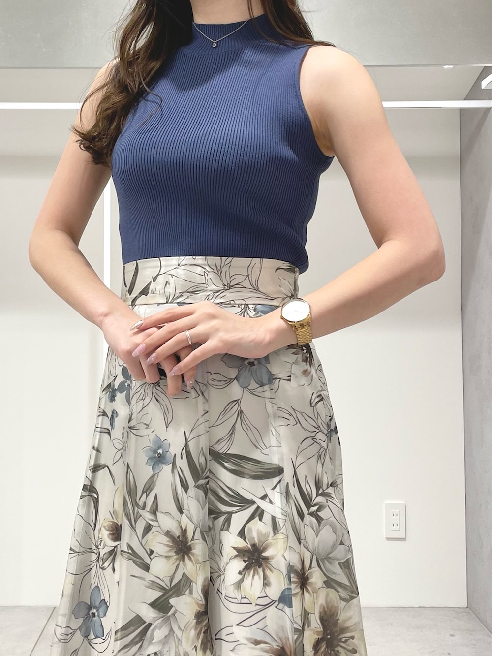 ホワイト系のベスト、グリーン系のスカート、ブルー系のニット/セーターを着用したレディースの春コーディネートの8枚目の写真