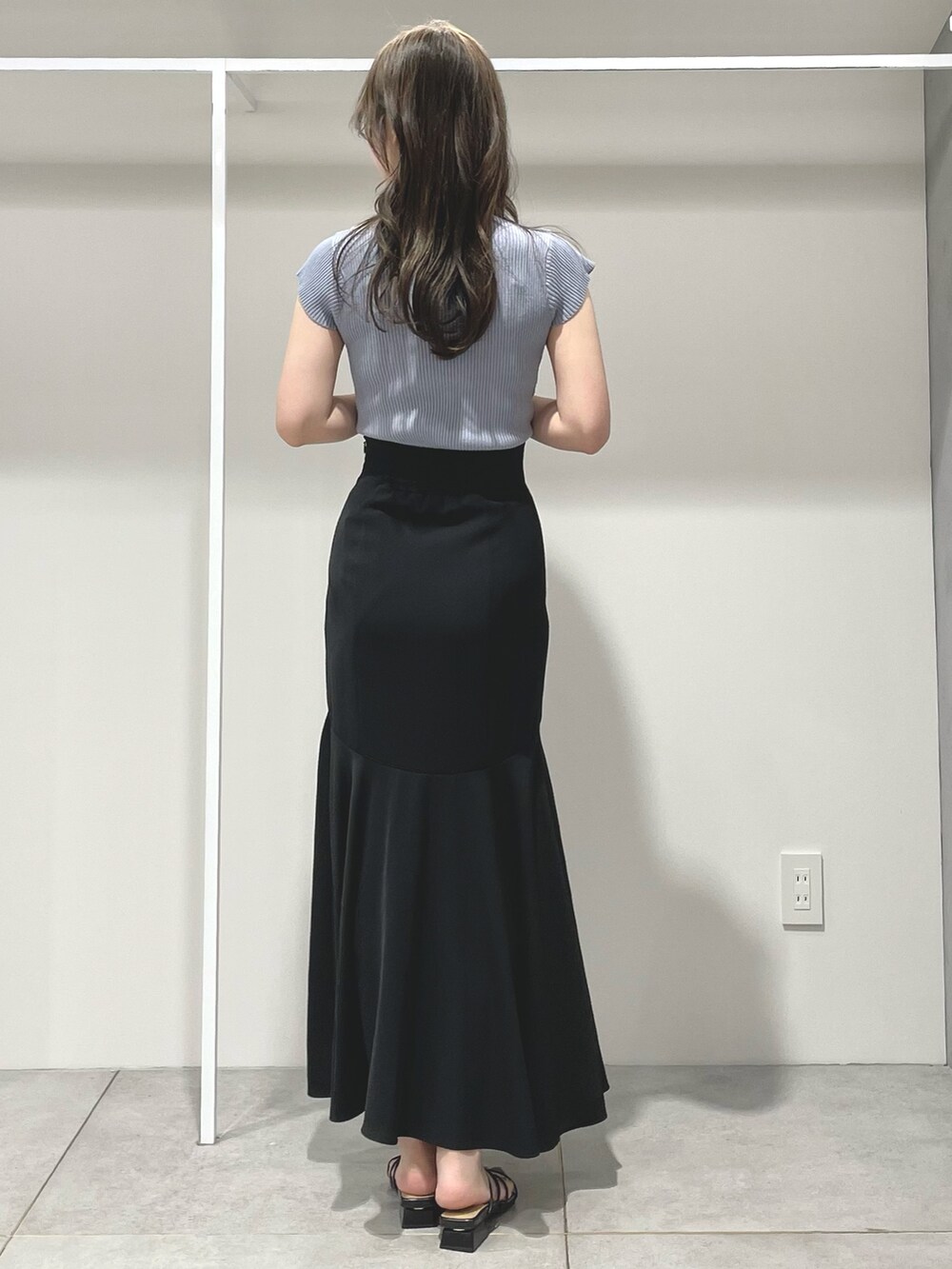 ブルー系のニット/セーター、ブラック系のスカート、ブラック系のサンダルを着用したレディースの夏コーディネートの4枚目の写真