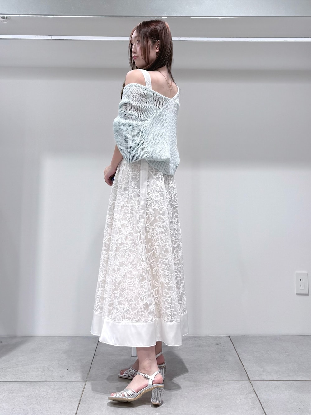 ブルー系のカーディガン/ボレロ、ホワイト系のワンピース、シルバー系のサンダルを着用したレディースの春コーディネートの3枚目の写真