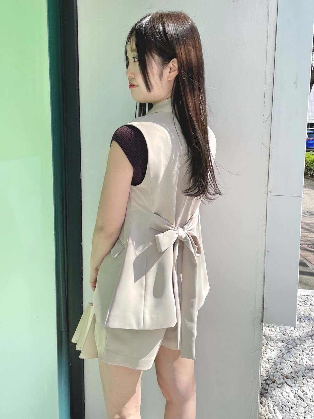 ベージュ系のその他パンツ、ホワイト系のハンドバッグ、ブラウン系のサンダルを着用したレディースの春コーディネートの5枚目の写真