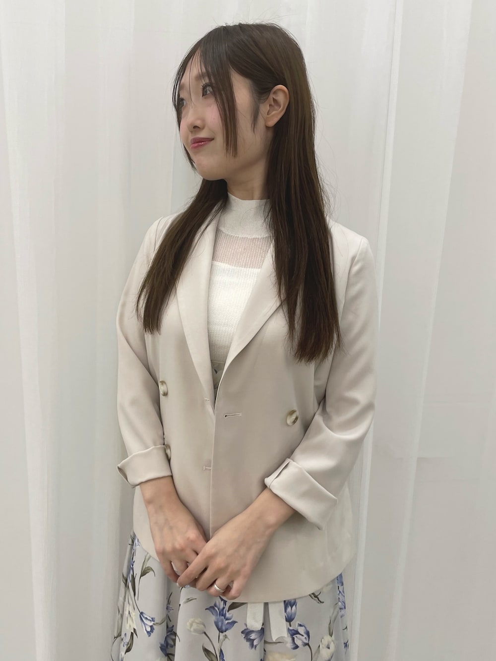 ブルー系のワンピース、ホワイト系のテーラードジャケット、ホワイト系のパンプスを着用したレディースの春コーディネートの4枚目の写真