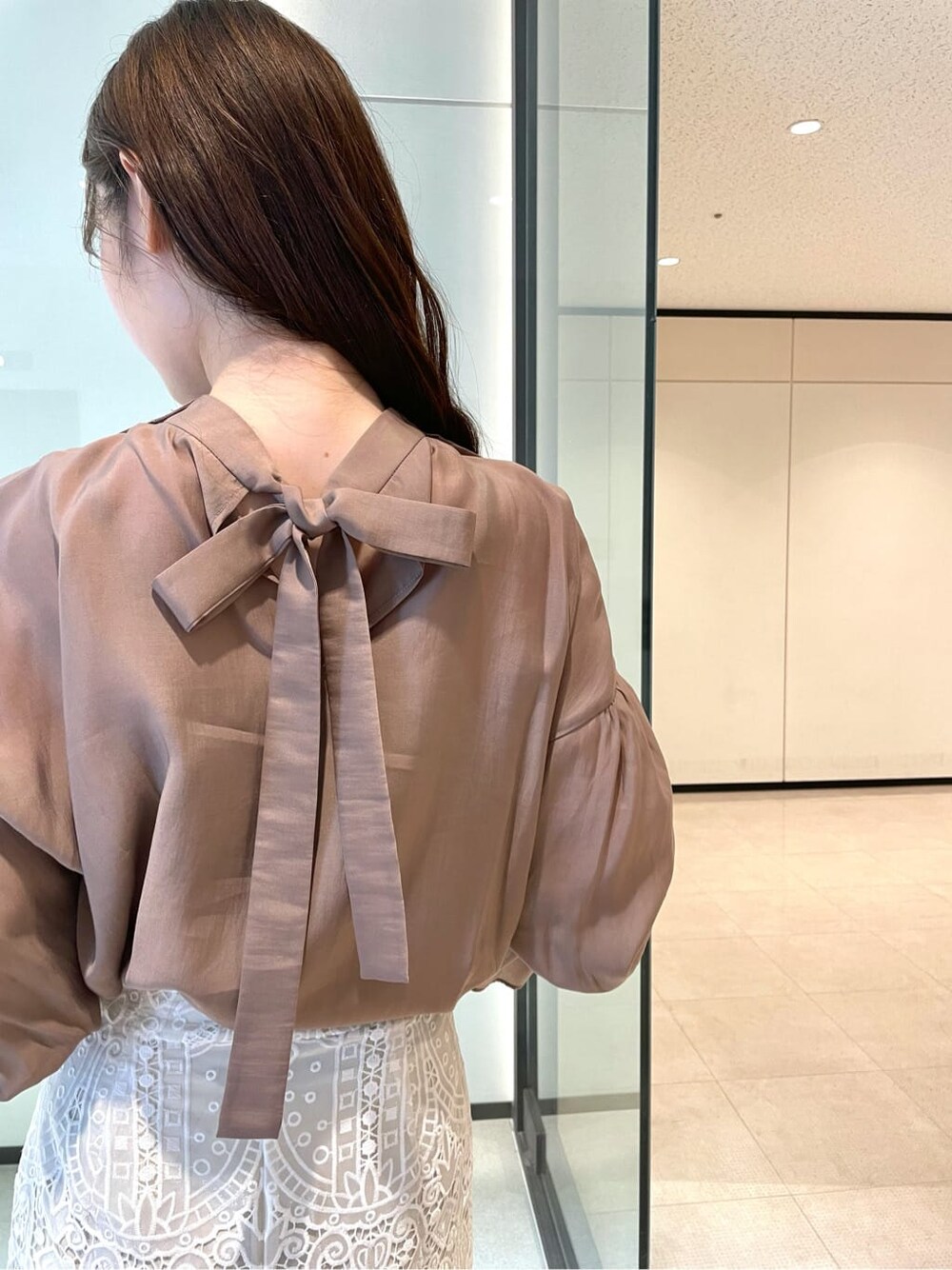 ピンク系のシャツ/ブラウス、ホワイト系のスカート、ベージュ系のパンプスを着用したレディースの夏コーディネートの4枚目の写真